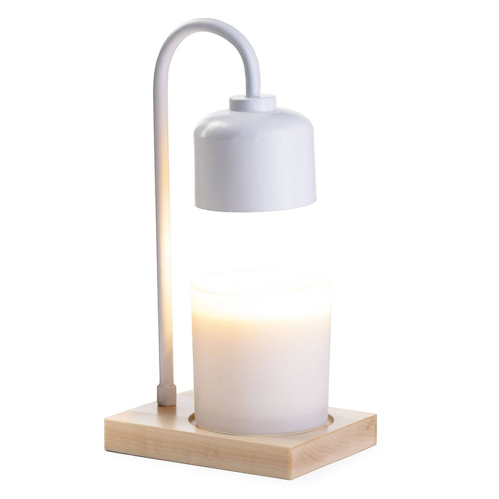 The Polka Dot Press white arched candle warmer lamp with a light wood base and a glowing jar candle on a white background