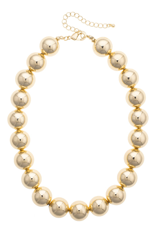 The Polka Dot Press Marjorie beaded necklace featuring chunky, shiny gold resin beads with an adjustable 16-inch chain.